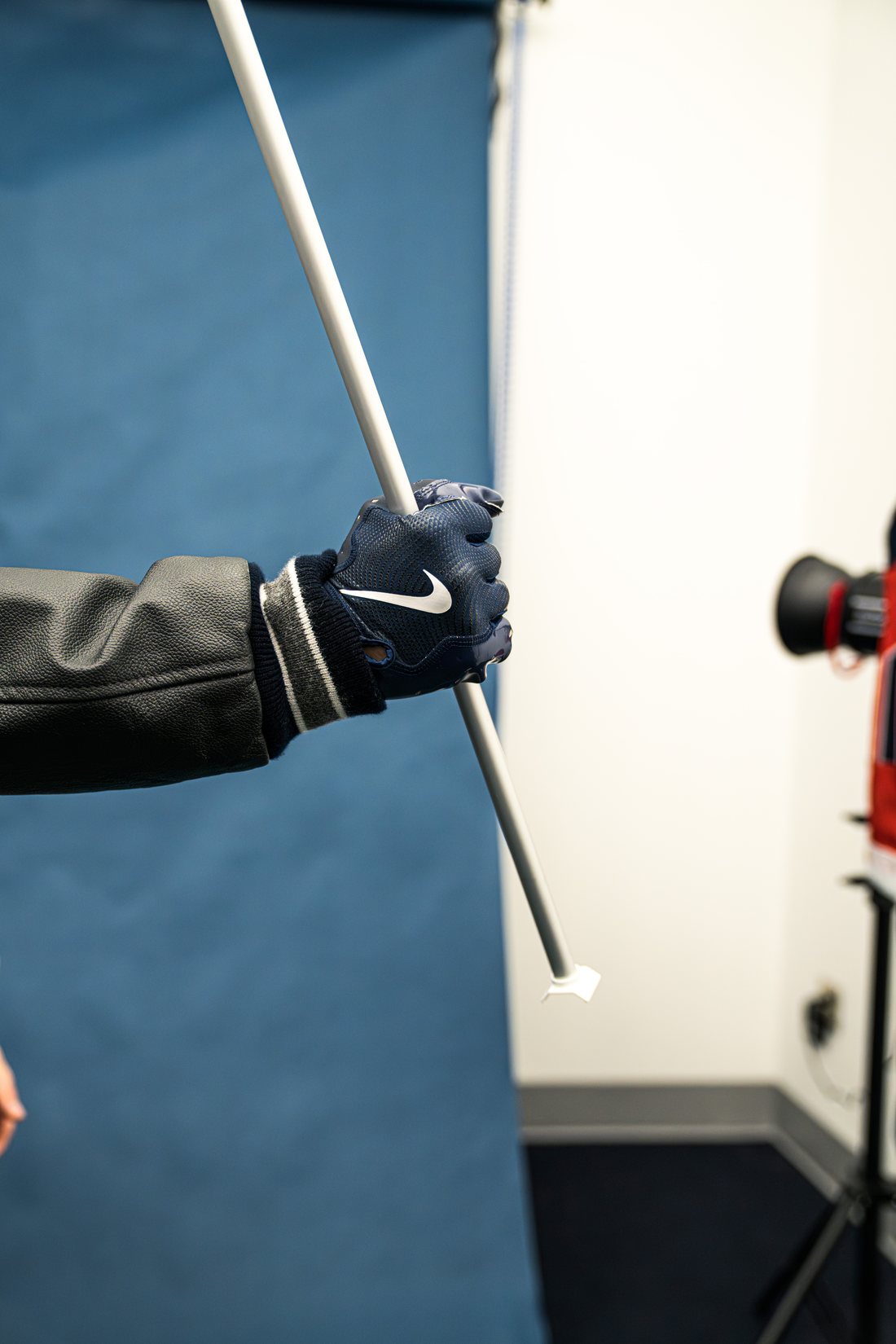 Cooper in the photo studio wearing a Nike glove, gripping a pole