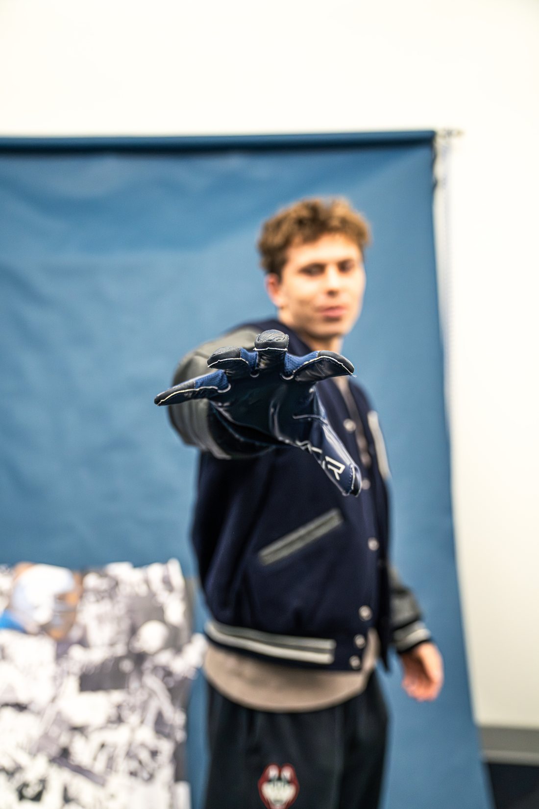 Cooper in the photo studio reaching toward the camera in a Nike glove